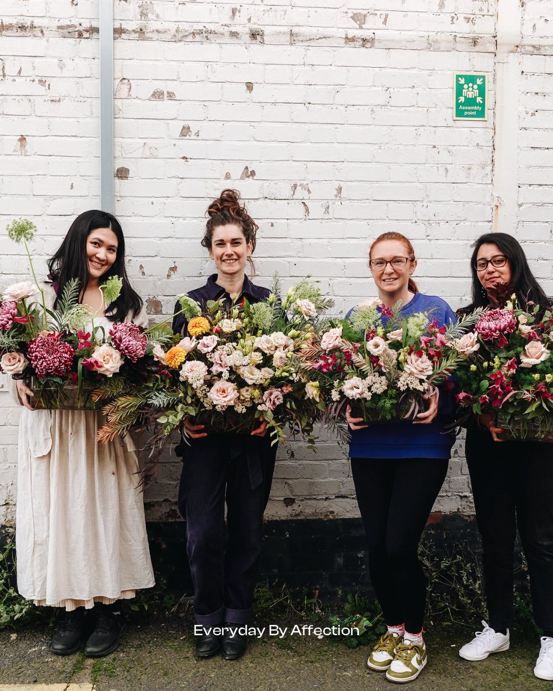 people holding flower arrangement after a floristry class