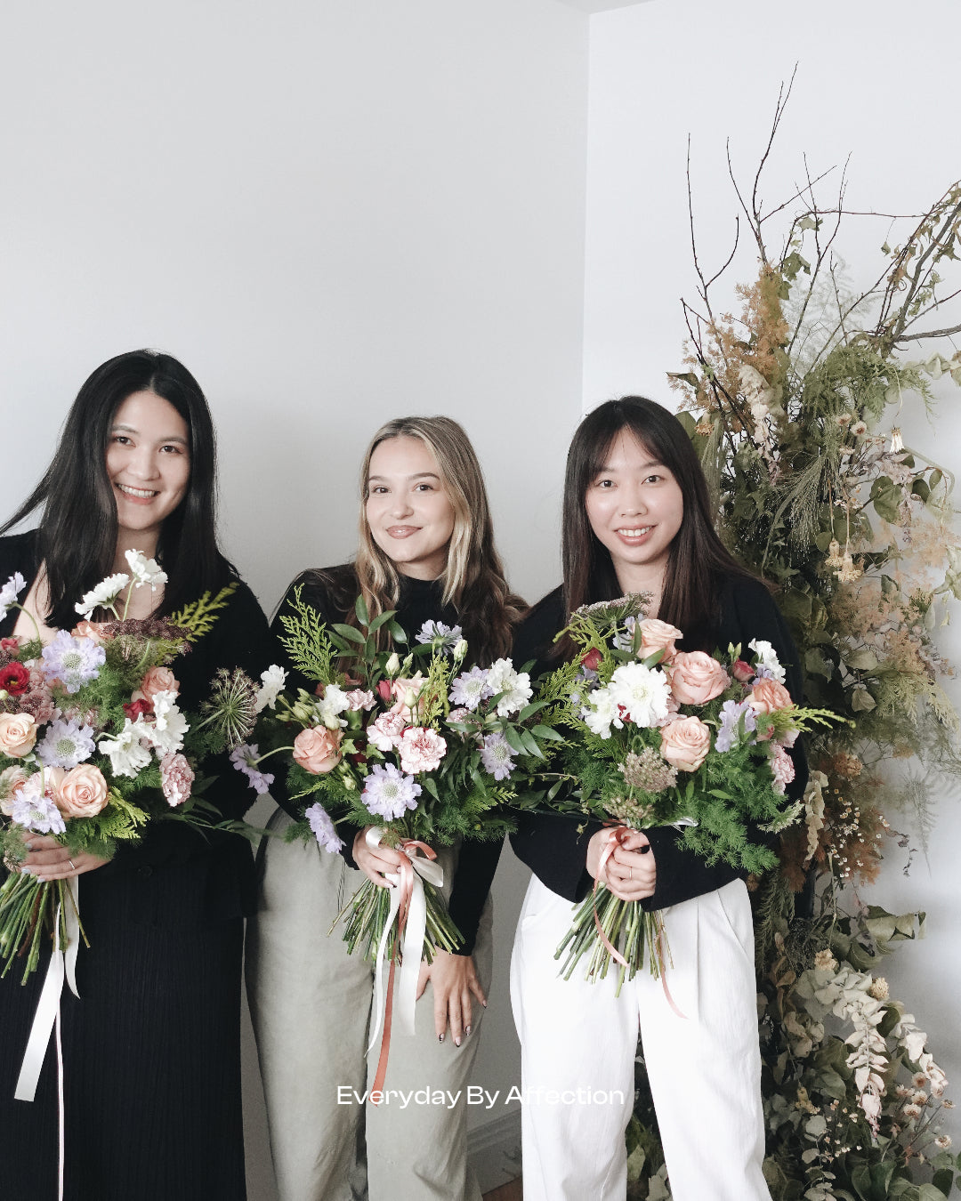 girls holding hand-tied bouquets in a floristry class