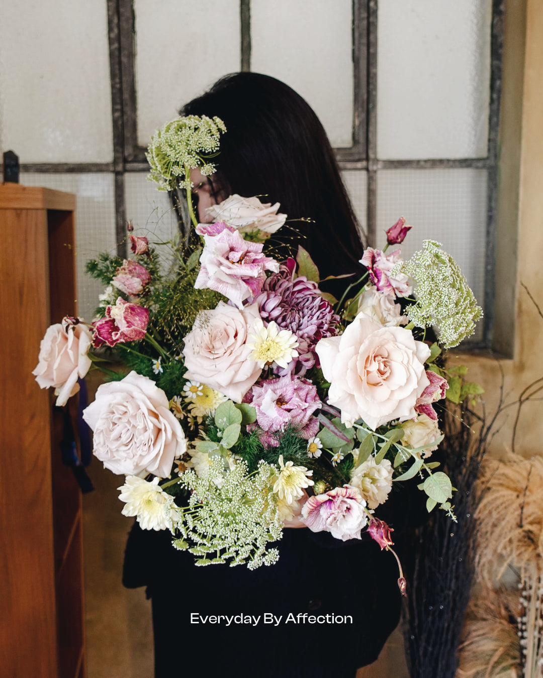 girl holding roses and green foliage