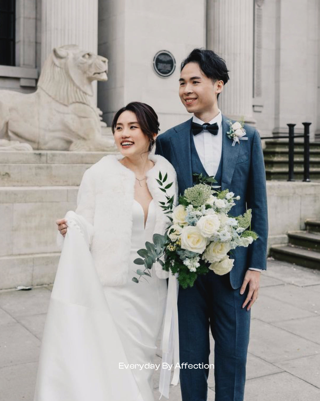 bride and groom holding a bouquet in white roses and blue delphiniums with eucalyptus