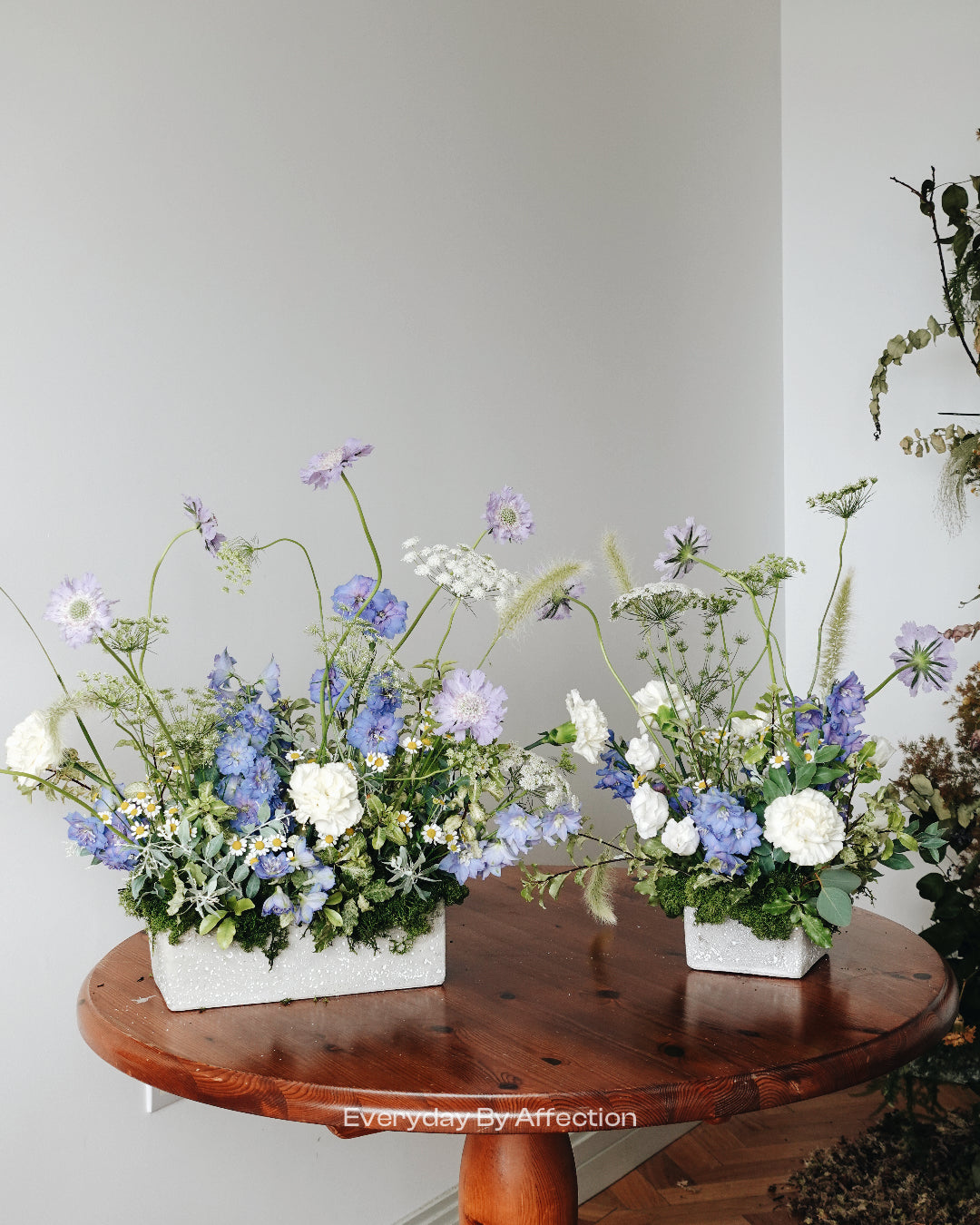 flower centrepiece in blue and white natural style on a wooden round table