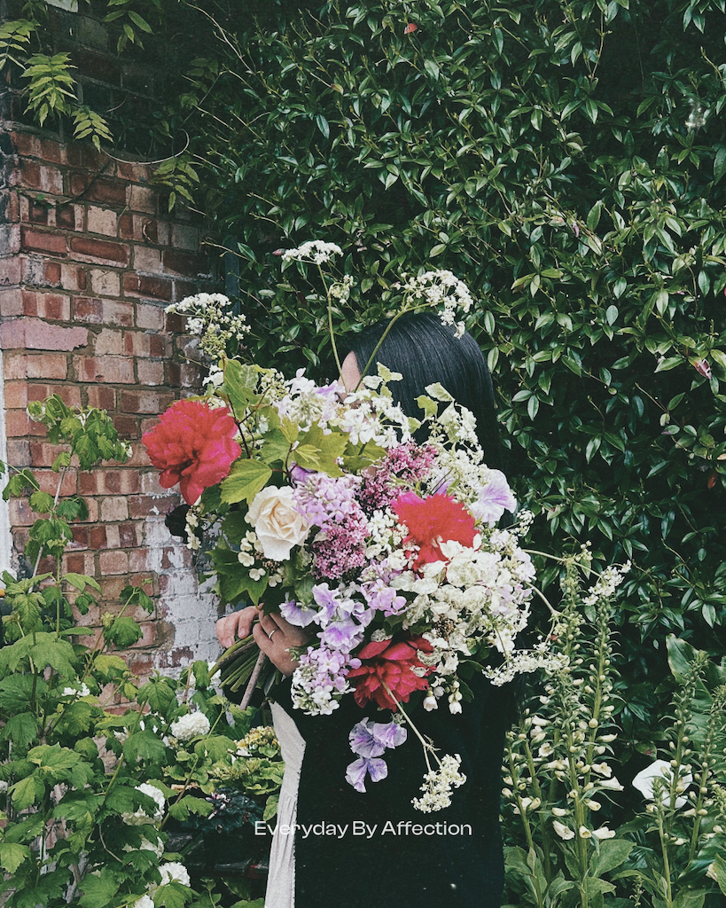 a girl holding a huge bunch of flowers