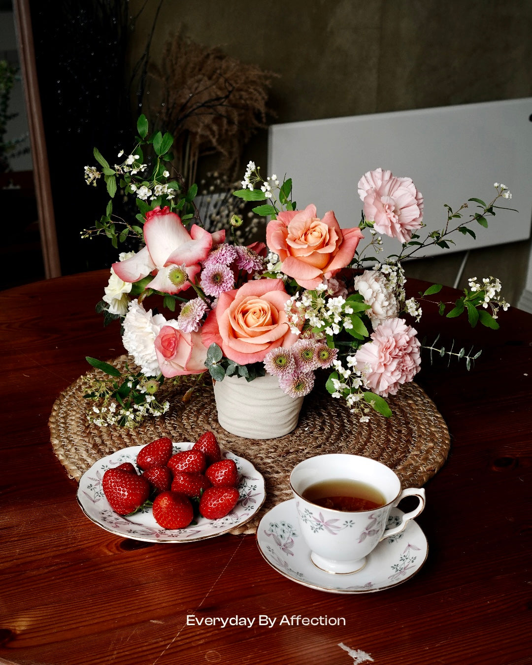 pink roses in vase with tea and strawberries