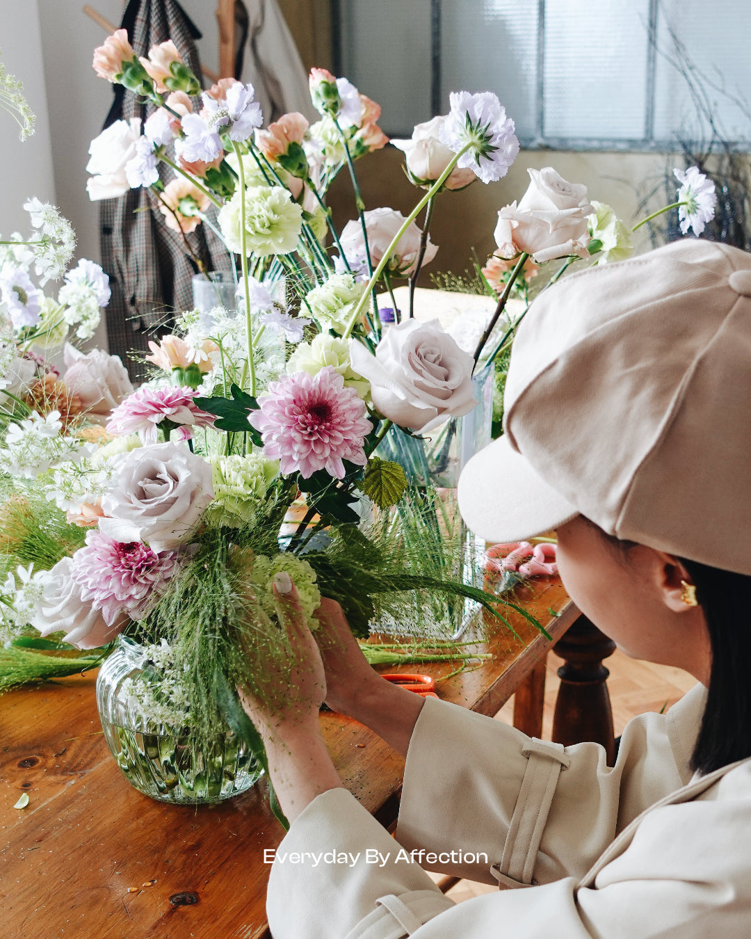 a girl arranging flowers in a vase at a flower arranging workshop