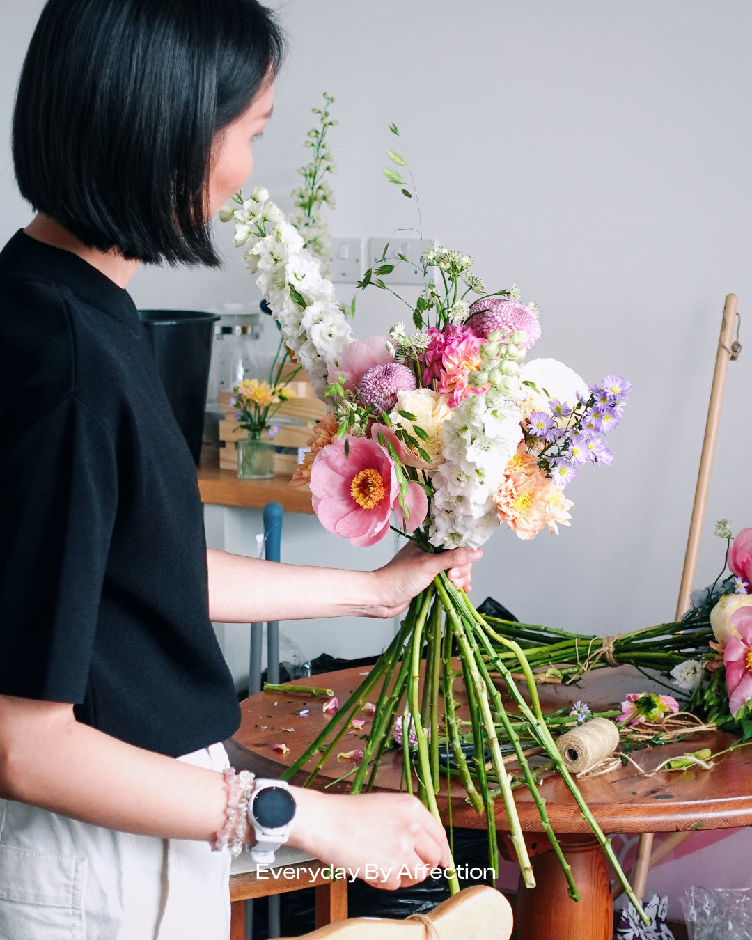 a girl demostrating how to make a handied flower bouquet