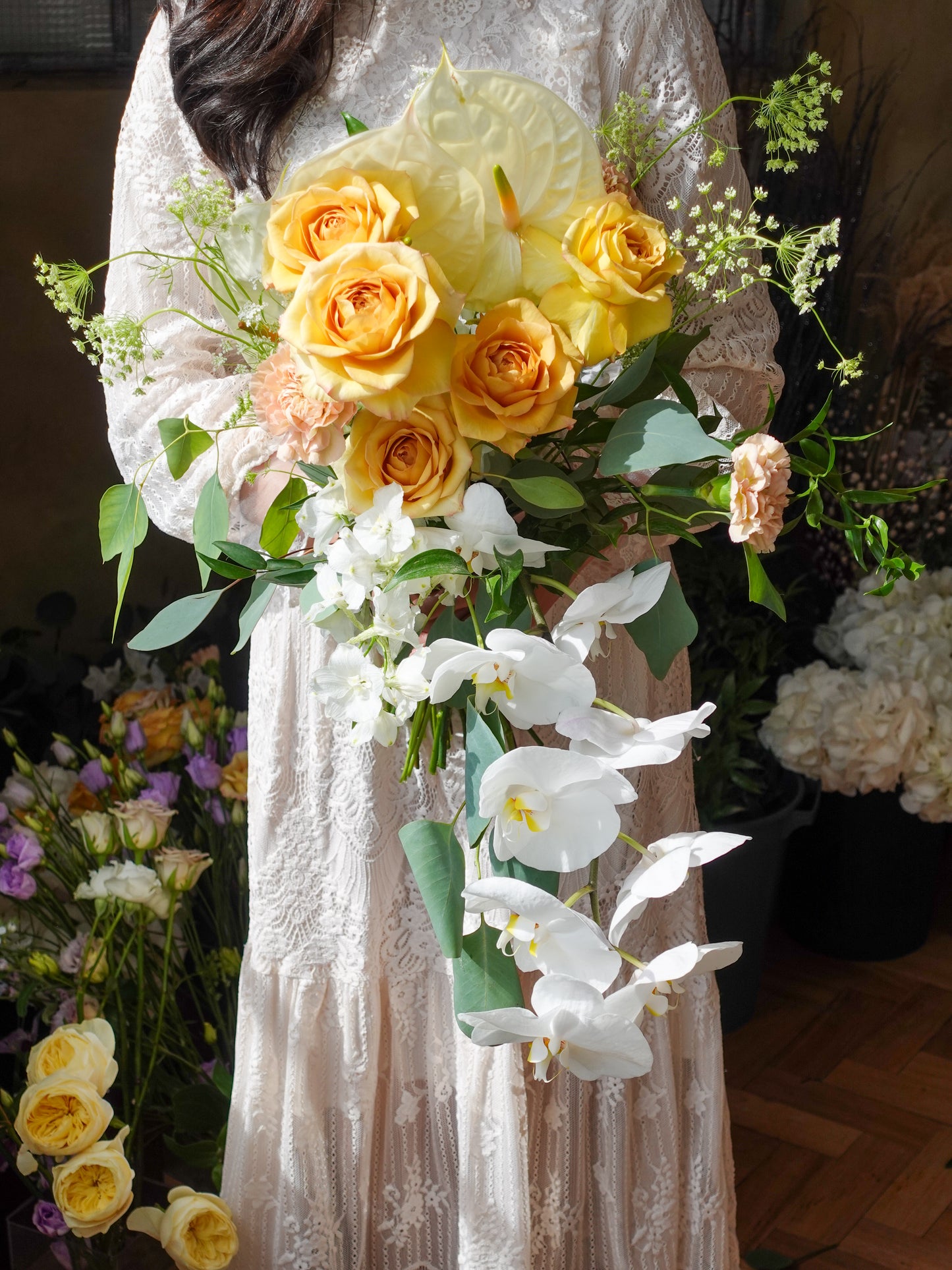 bridal bouquet in roses and orchids and green leaves