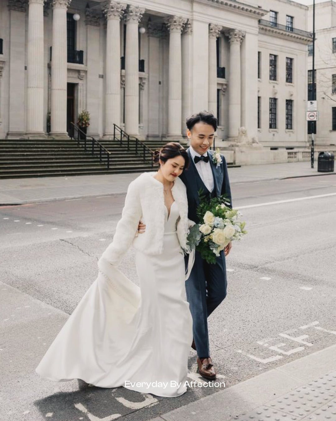 birde and groom in front of london city hall holding a bridal bouquet