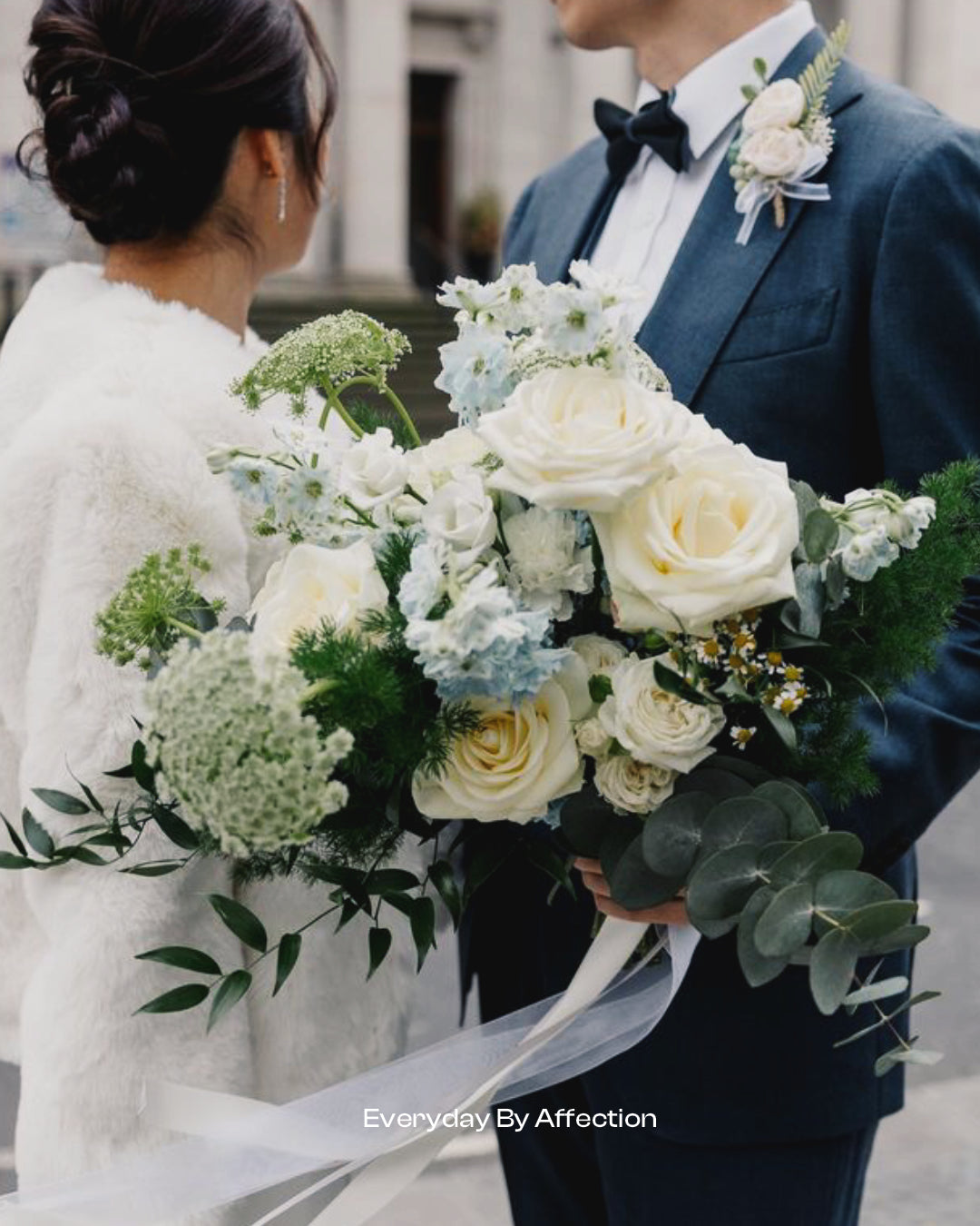 luxurious bridal bouquet in white roses queen anne's lace blue delphinum with green fern and eucalyptus