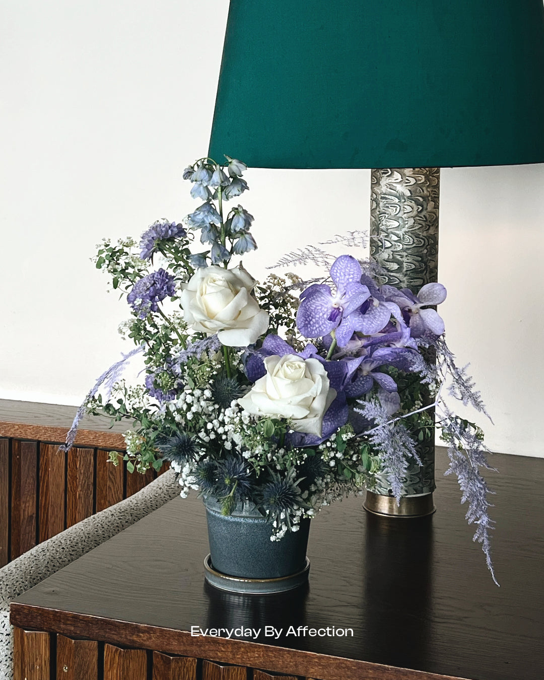 blue vase with white and purple flowers